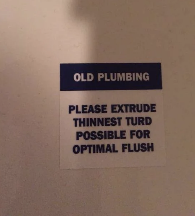 Sign reads &quot;OLD PLUMBING PLEASE EXTRUDE THINNEST TURD POSSIBLE FOR OPTIMAL FLUSH&quot; on a wall