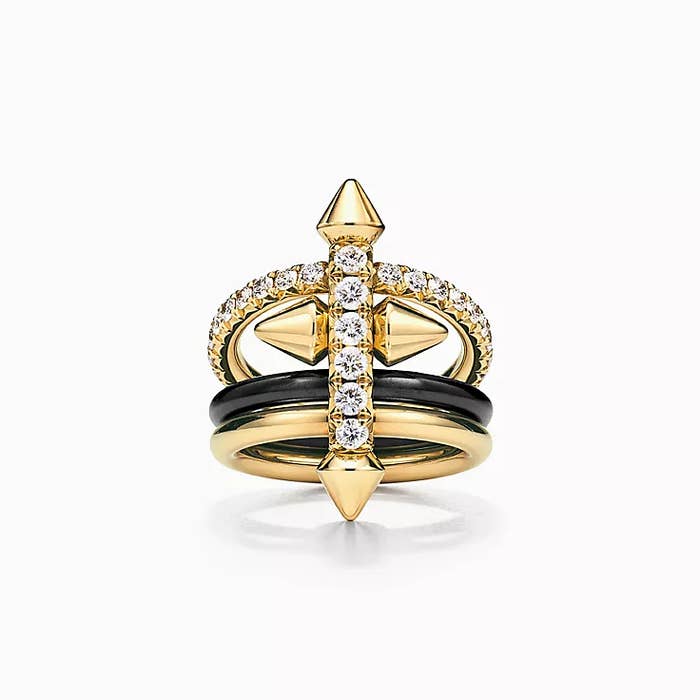 Gold ring with a diamond-encrusted cross design and black enamel bands