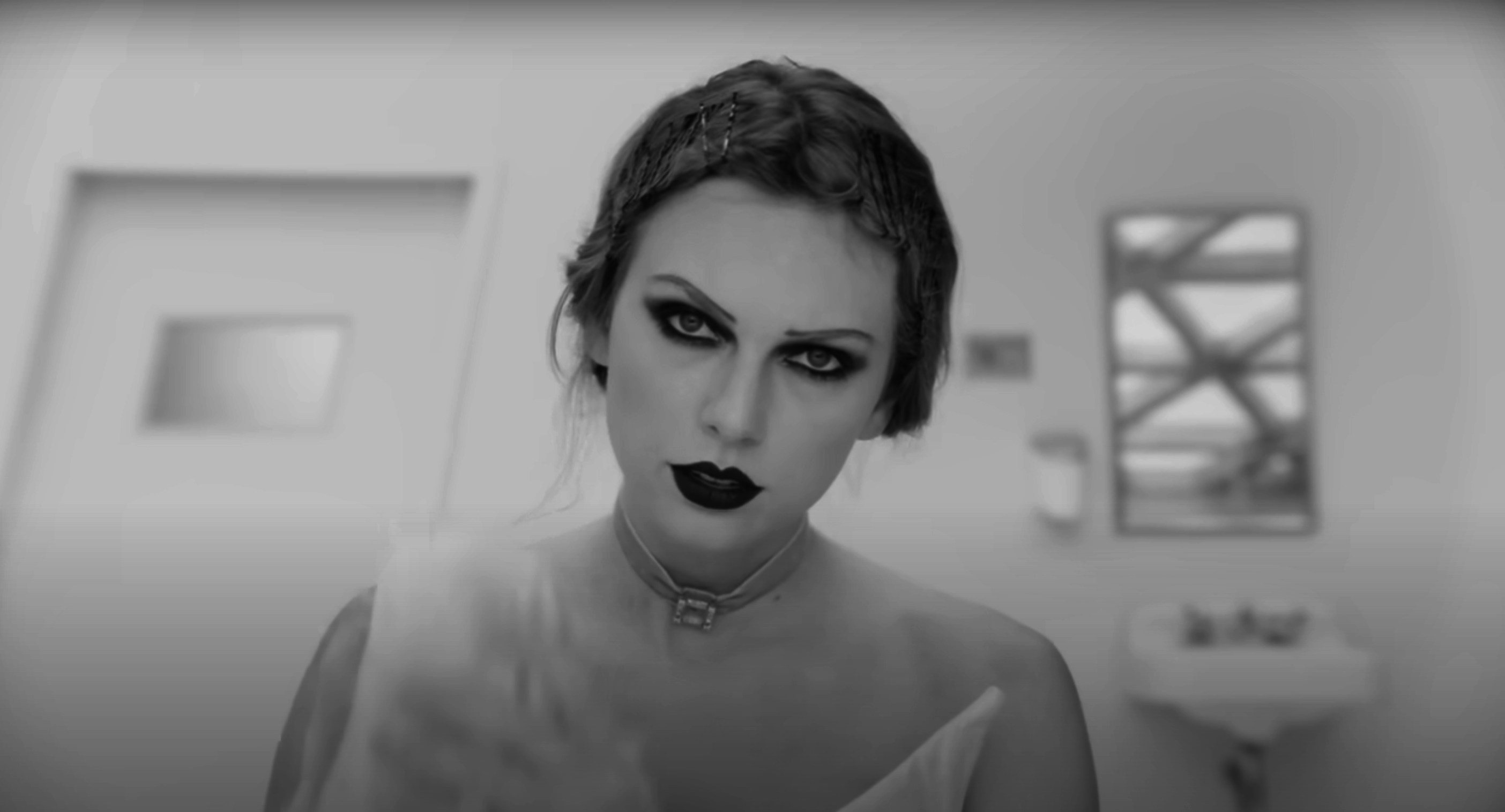 Taylor Swift in a dramatic makeup look, gazing intensely at the camera