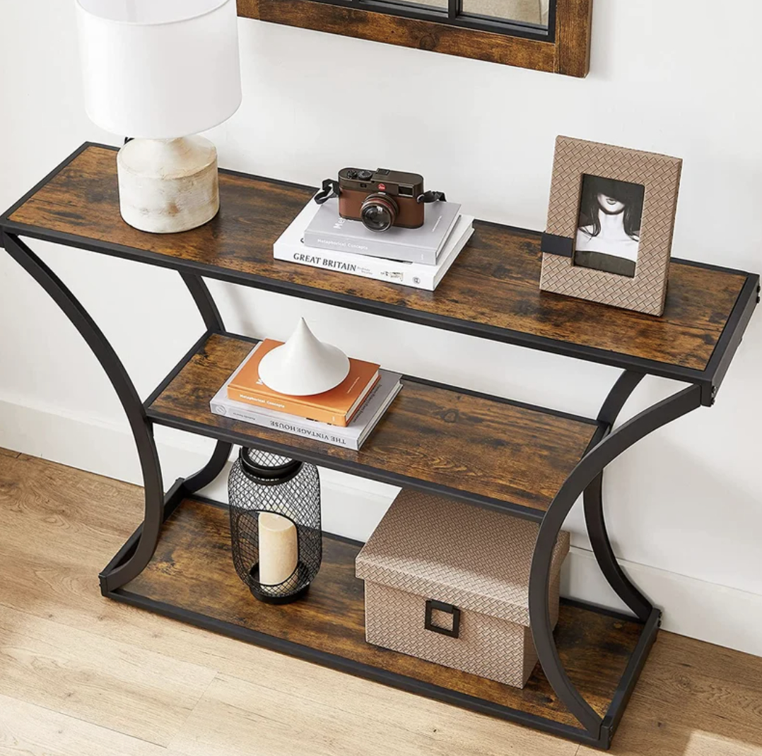 Console table with decorative items including a lamp, camera, books, and framed photo
