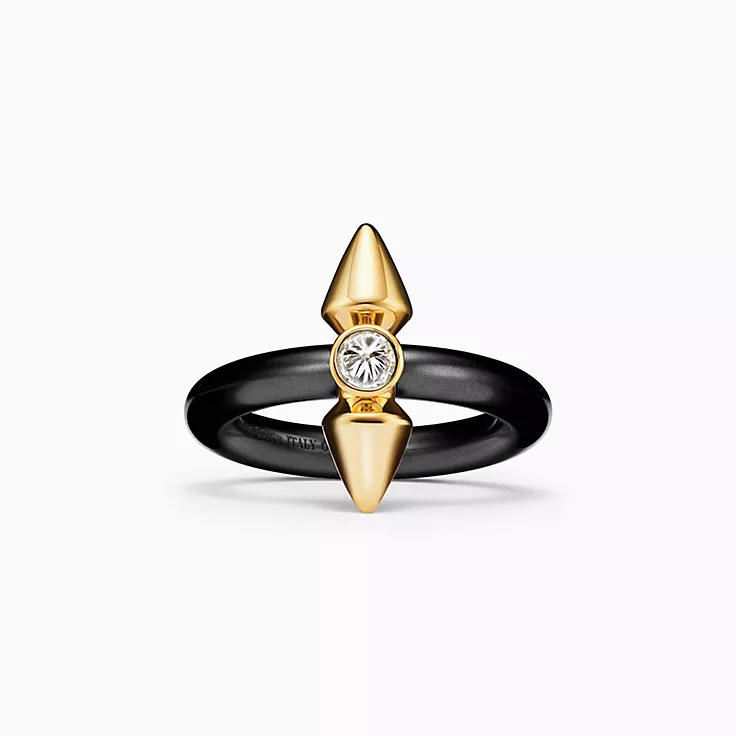 A black and gold ring with a central diamond and spiked embellishments
