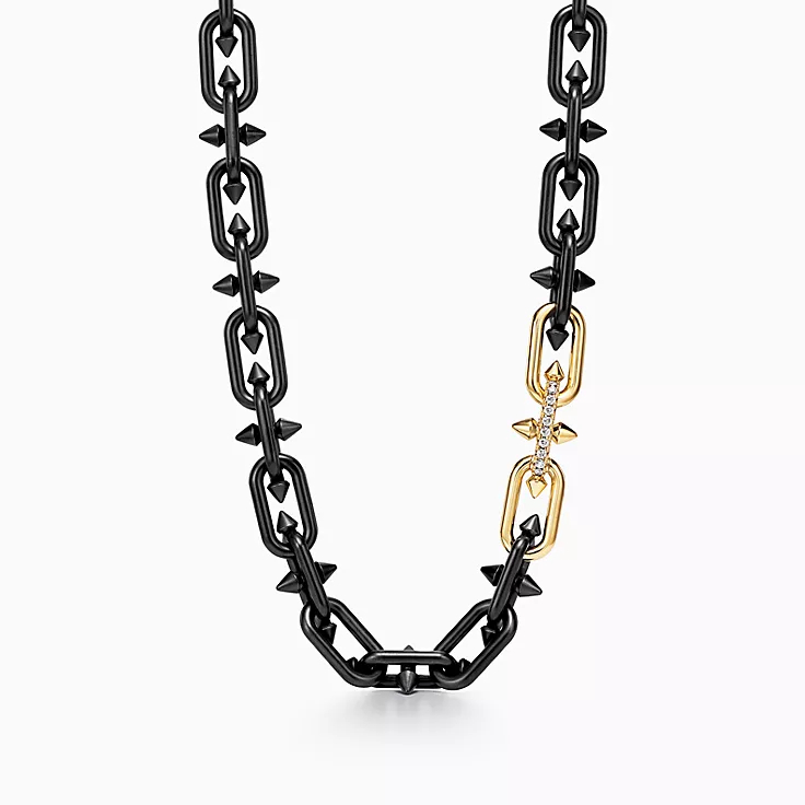 Chunky chain necklace with contrasting black links and a single gold link with a pendant