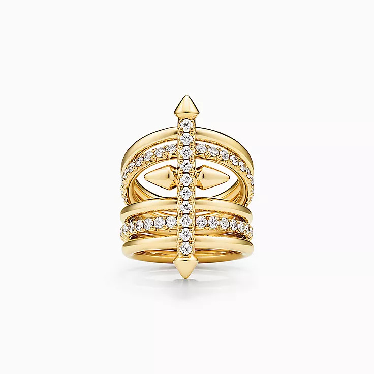 Gold ring featuring a unique wrap design with a central arrow motif, encrusted with small diamonds