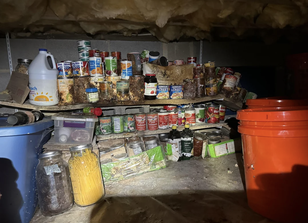 A cluttered pantry shelf with various food items, containers, and a jug
