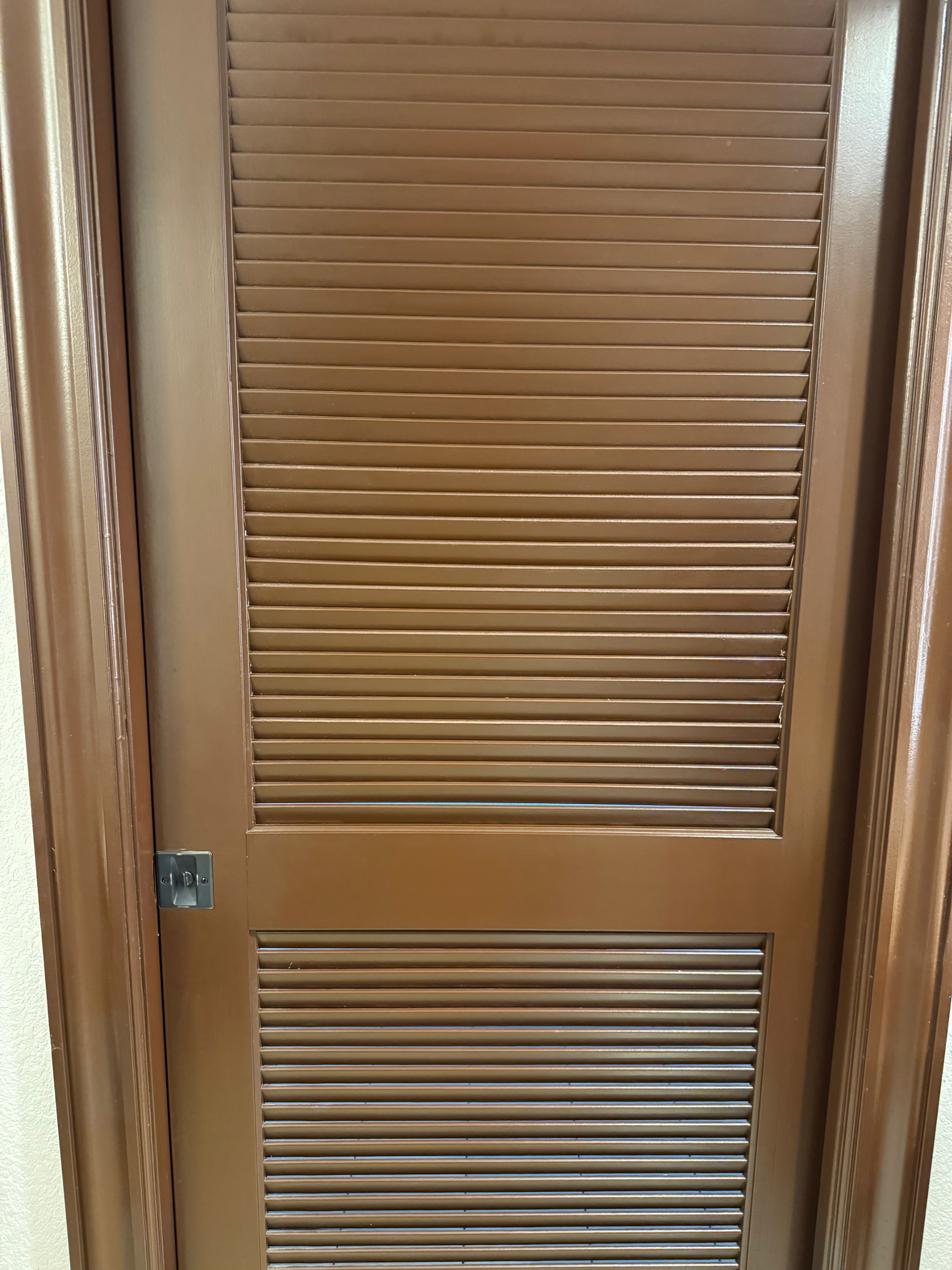 Brown door with horizontal slats, part of a building&#x27;s interior architecture