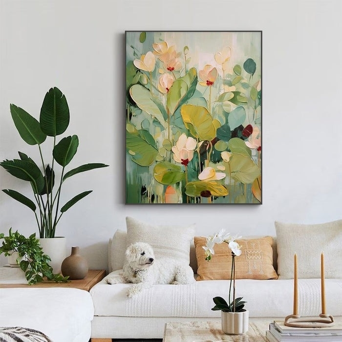 Artwork of abstract flowers above a couch with cushions, a dog resting on it, and indoor plants nearby
