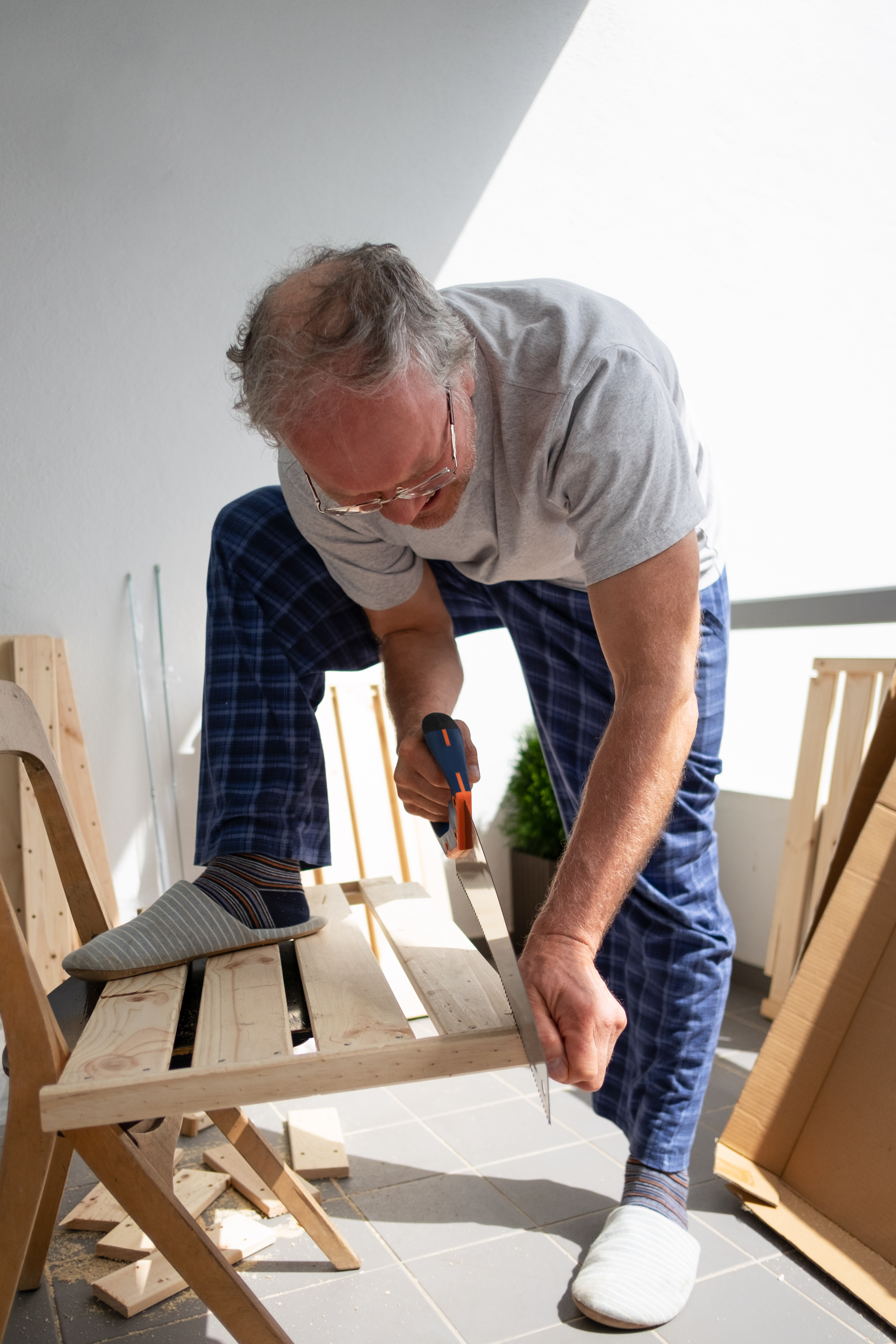 Man assembling wooden furniture with a screwdriver at home