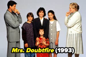 Cast of 'Mrs. Doubtfire' posing together, with a character in a nanny outfit
