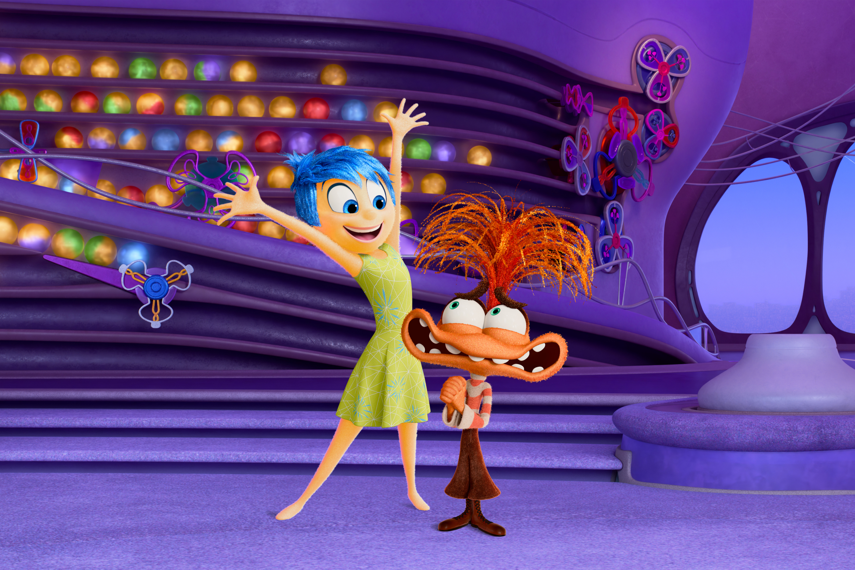 Animated characters Joy and Fear from Inside Out, Joy is smiling with arms raised, Fear is grimacing. They stand in front of a whimsical, purple backdrop