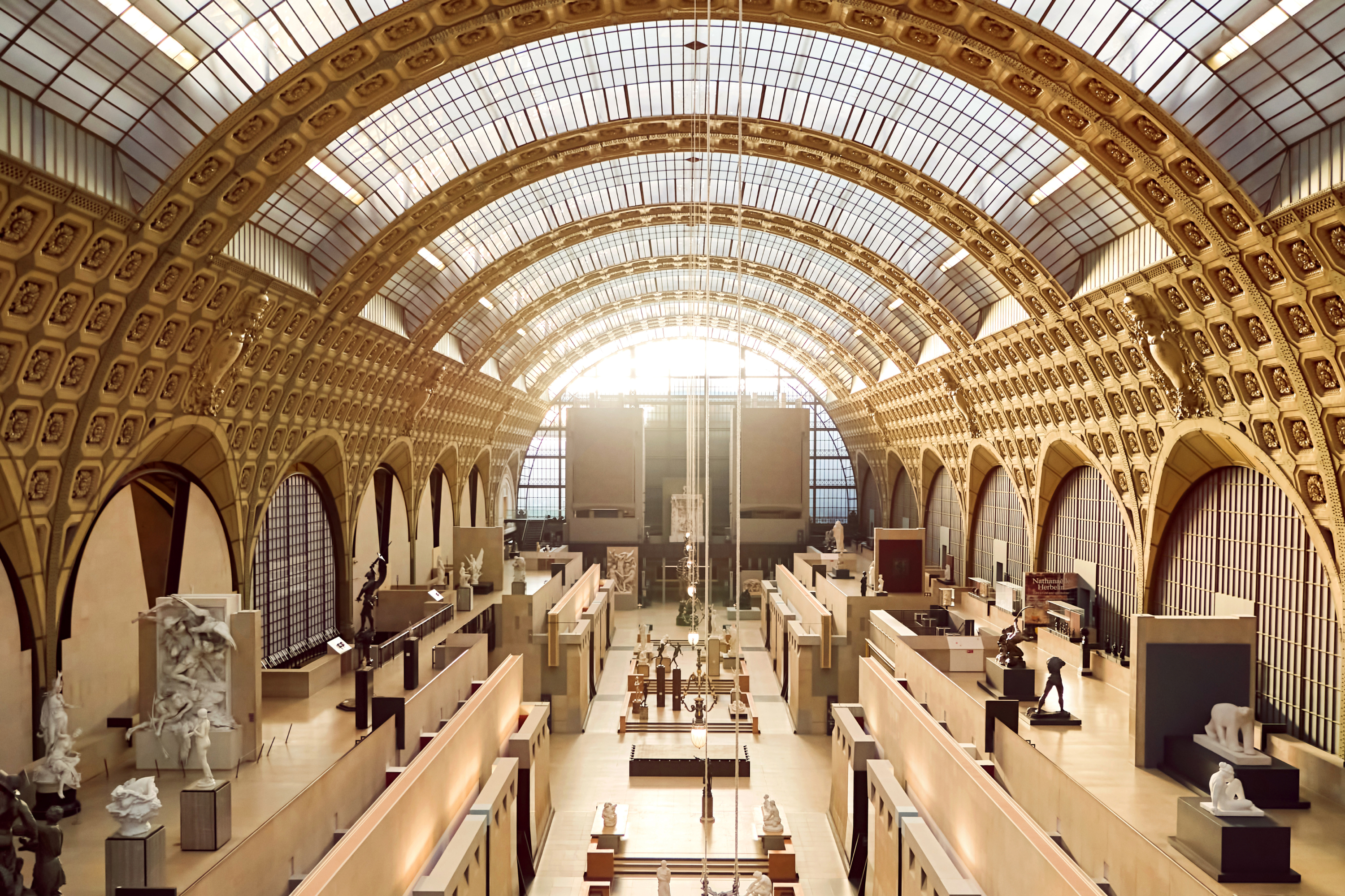 Interior view of the Musée d&#x27;Orsay showing sculptures, arches, and the grand clock