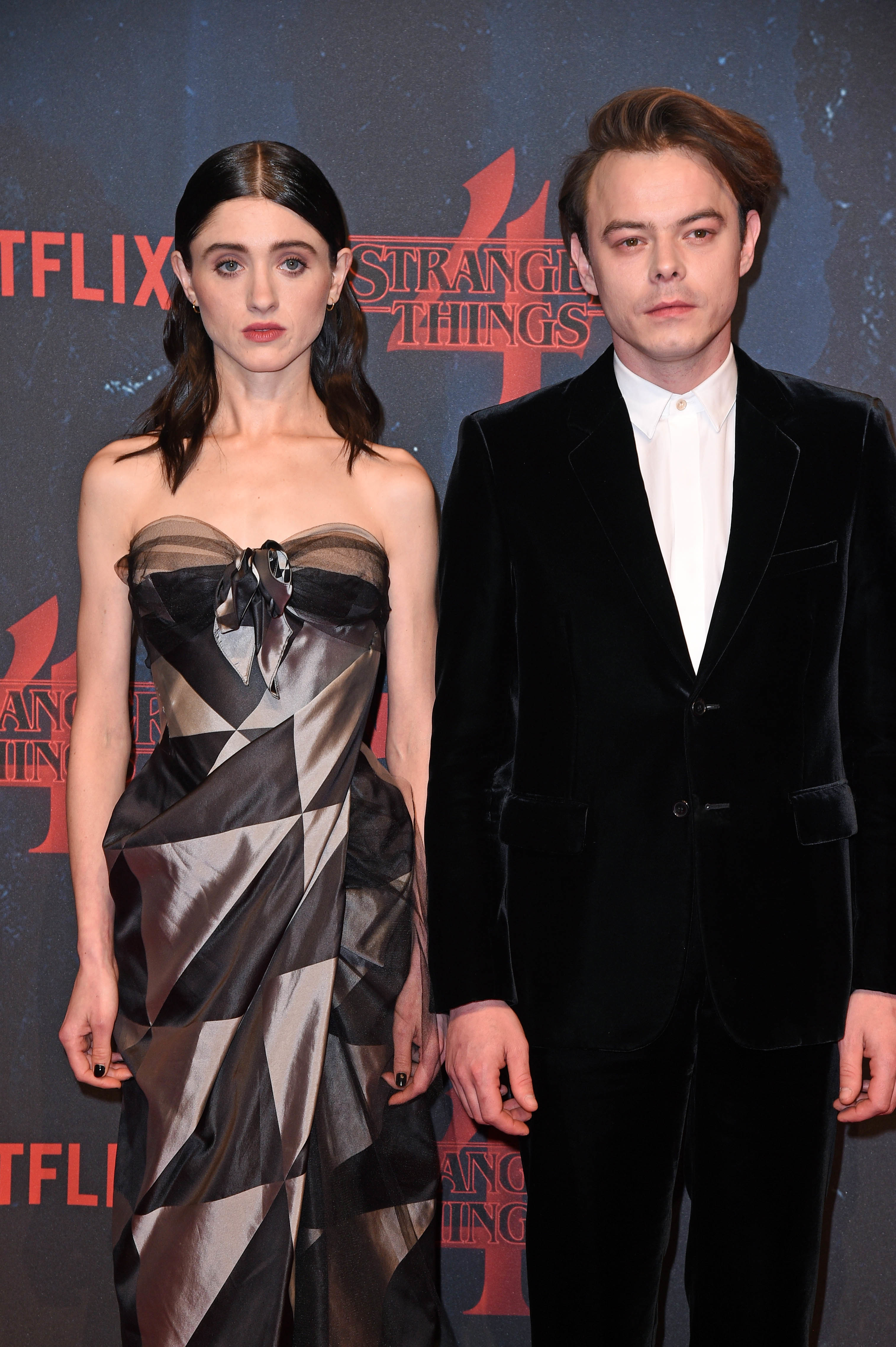Two actors at a &#x27;Stranger Things&#x27; event, woman in a strapless dress with bow detail, man in black velvet suit
