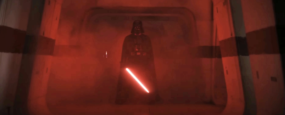 Darth Vader holding a red lightsaber in a dark, foggy corridor