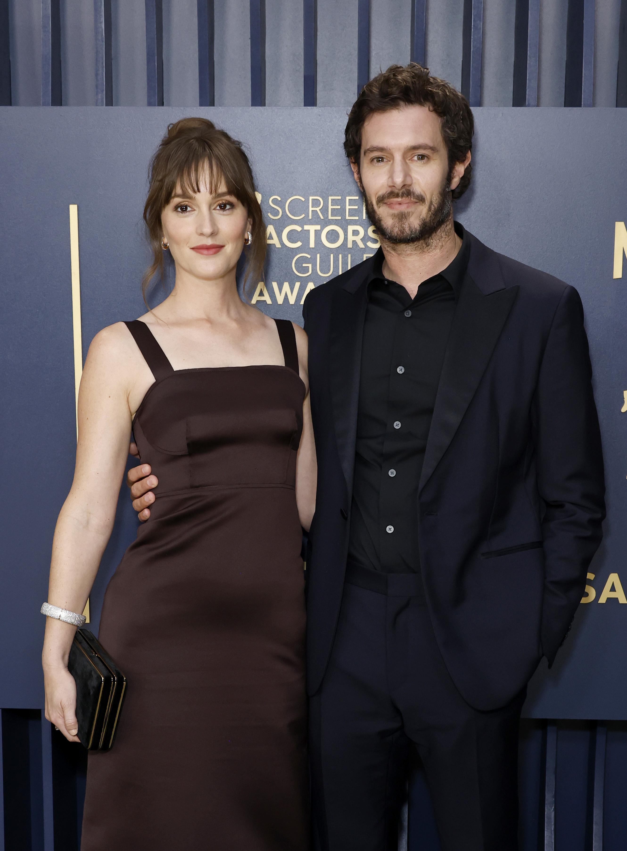 Dakota Johnson in a strapless dress with Adam Scott in a suit, posing together at the SAG Awards