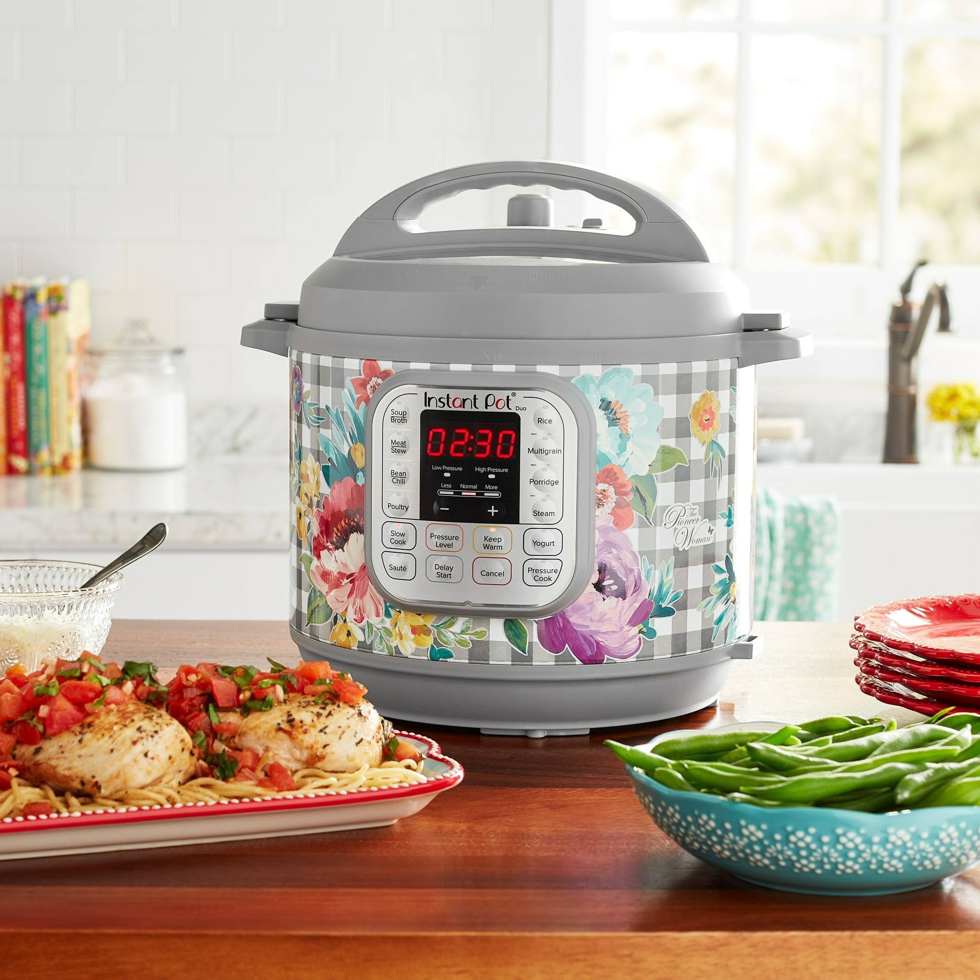 A floral-patterned Instant Pot on a kitchen counter with food dishes nearby