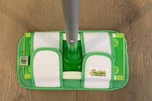A swiffer mop with a reusable mop pad attached