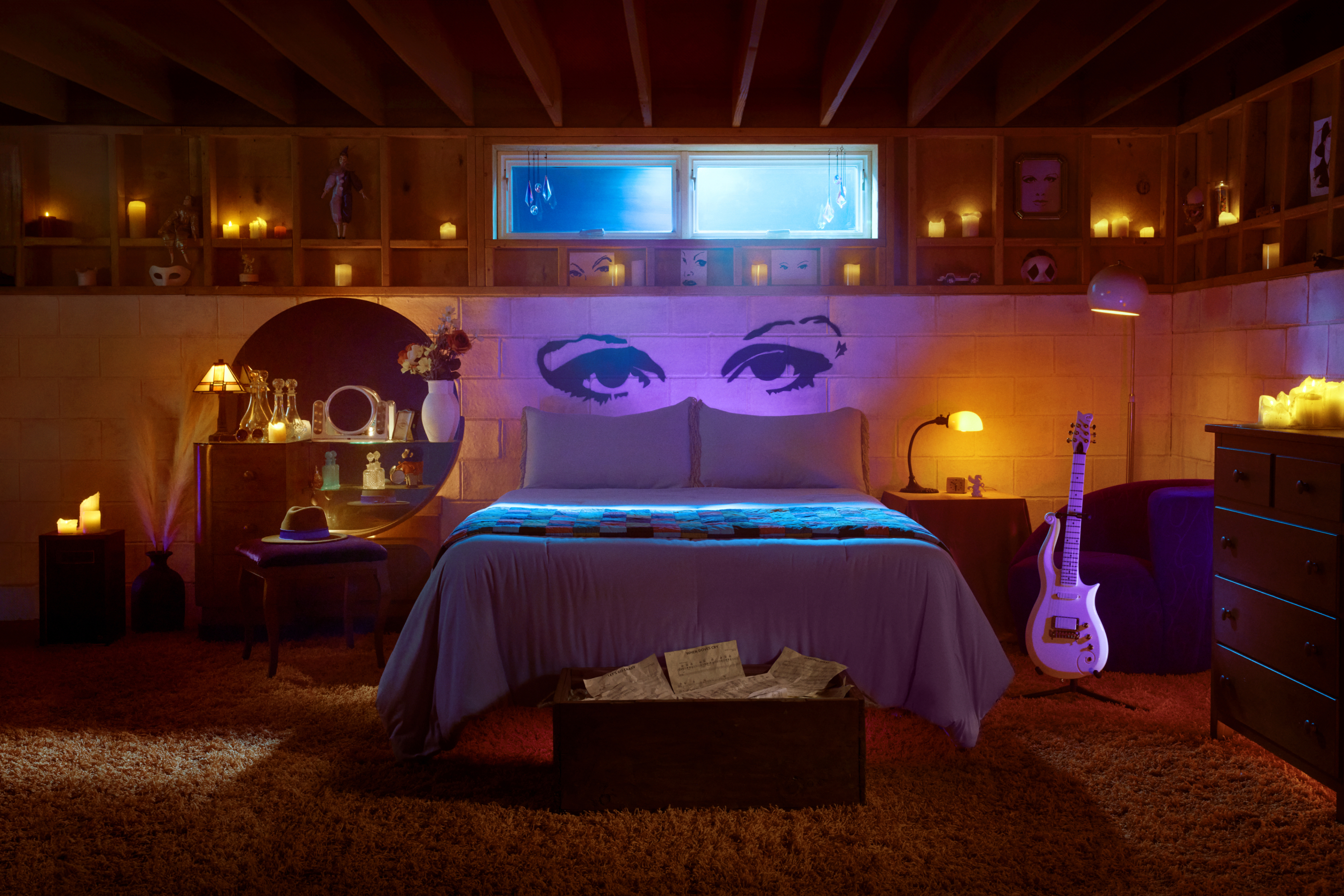Bedroom with an iconic pop art portrait above the bed, electric guitar by the side, and ambient lighting