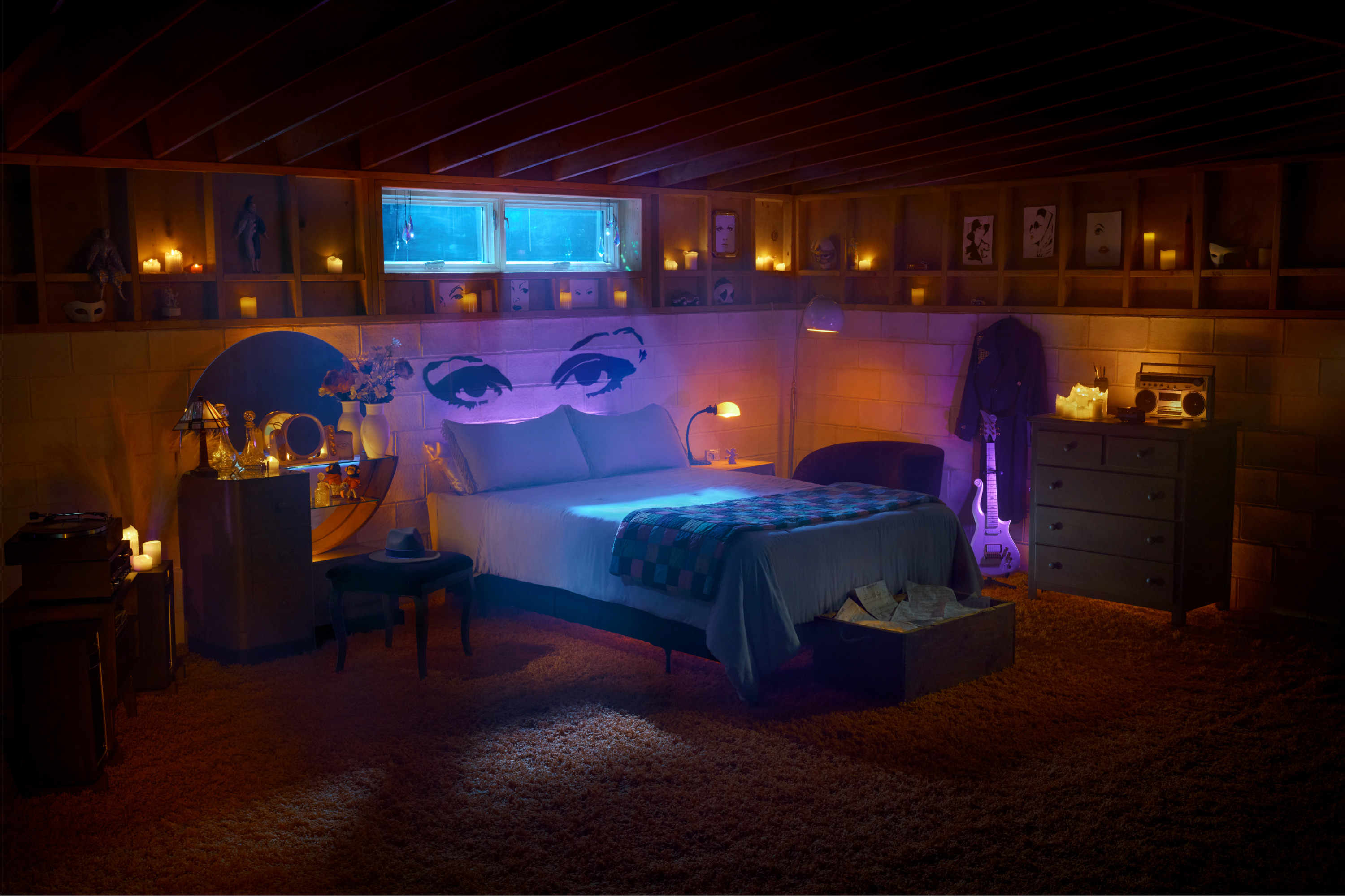 Cozy bedroom at night with lit candles, bed, furniture, and various decorations