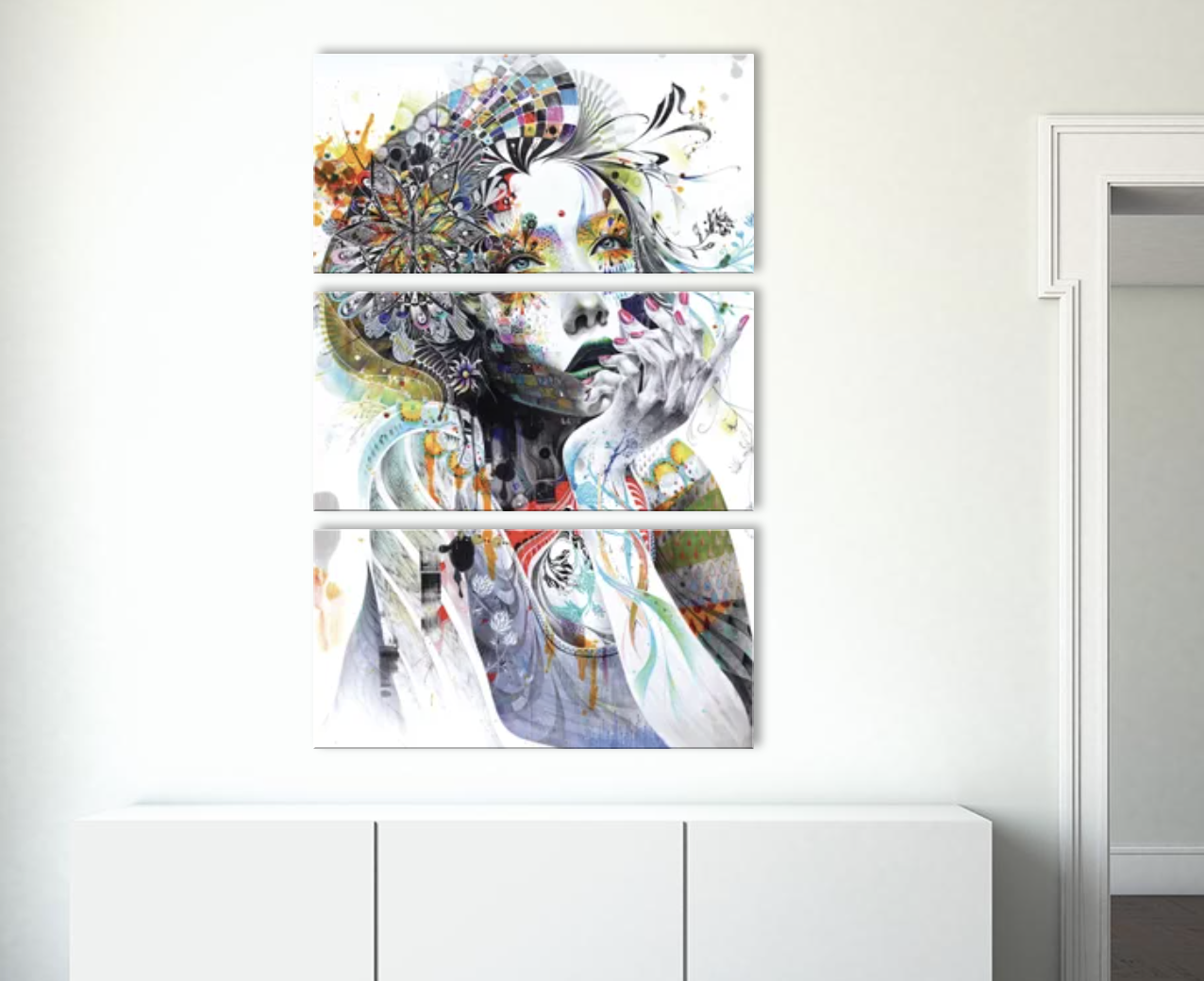 Abstract art canvas in three panels with a mix of floral and whimsical elements on a white cupboard