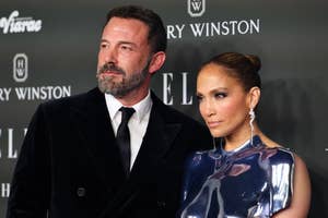 Ben Affleck and Jennifer Lopez at a red carpet event. Ben wears a black velvet suit; Jennifer wears a shiny, metallic top with a high neck