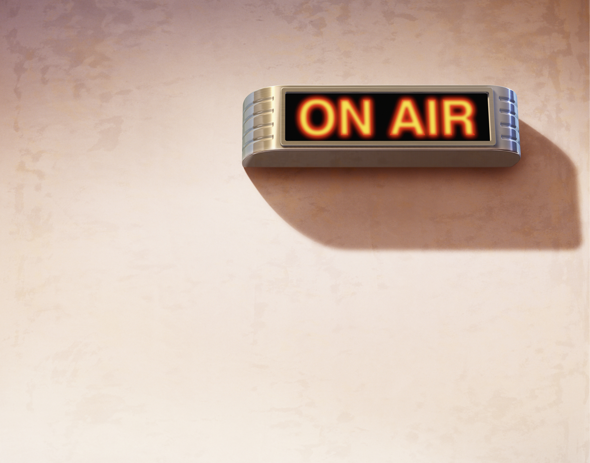 A lit &quot;ON AIR&quot; sign is mounted on a wall, indicating that a live broadcast or recording is in progress