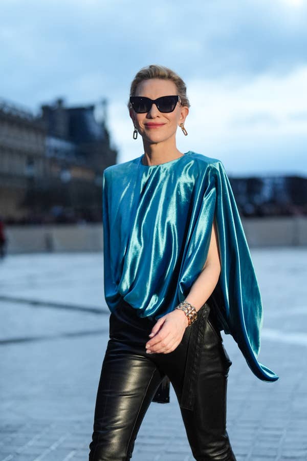 Cate Blanchett in leather pants and a stylish draped top, wearing sunglasses
