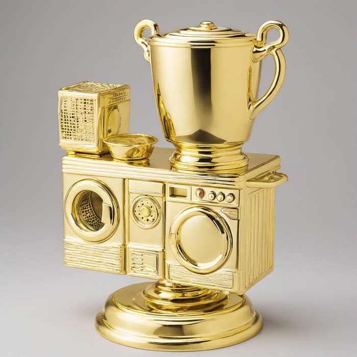 A trophy shaped like household appliances: a washing machine, dryer, and laundry basket, all golden
