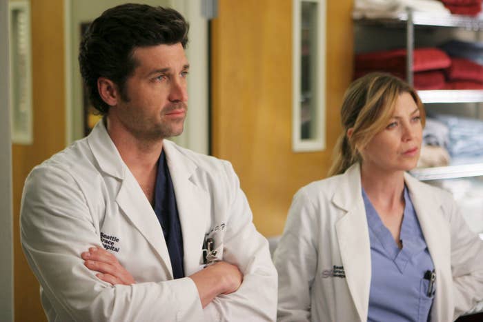 Patrick Dempsey and Ellen Pompeo wearing medical scrubs under white lab coats