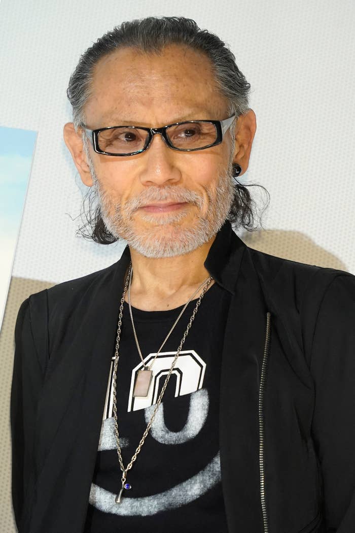 男性が黒いジャケットと眼鏡を着用してカメラを見ている。