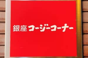 Sign with Japanese characters on red background, mounted on a brick wall