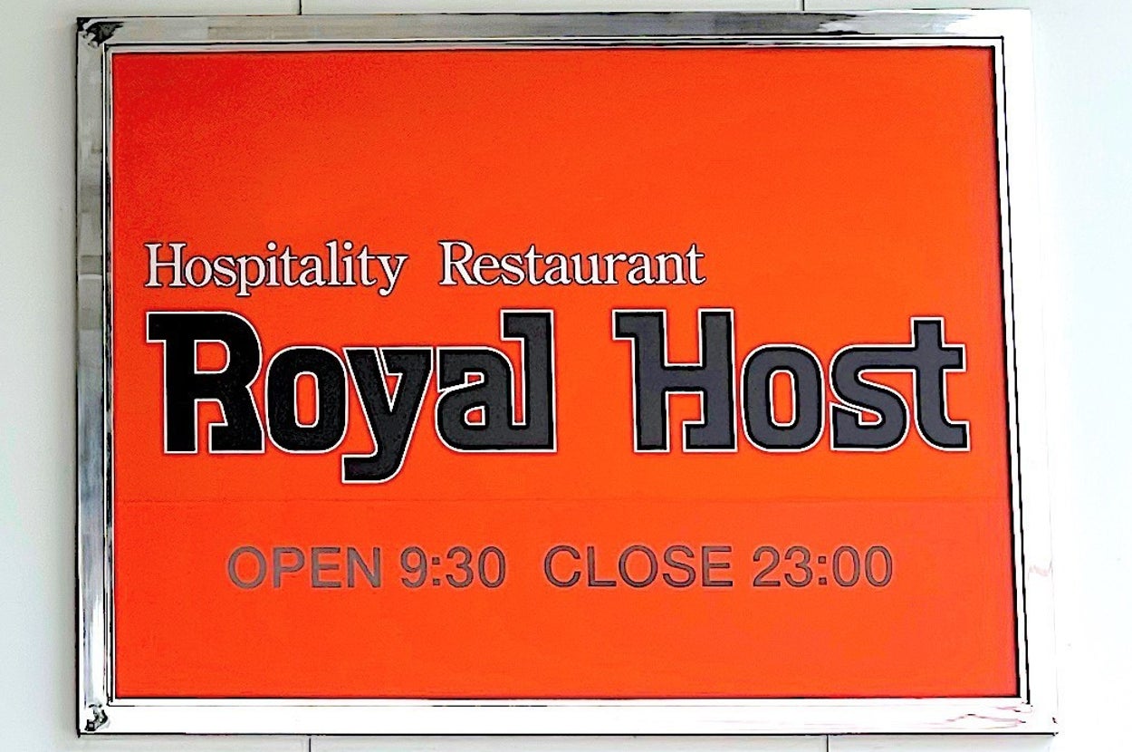 Sign on the wall reads, "Hospitality Restaurant Royal Host. OPEN 9:30 CLOSE 23:00."