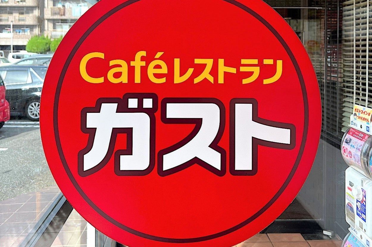 Sign for the restaurant chain Gusto, featuring a red circle with the text "Café Restaurant Gusto" in Japanese