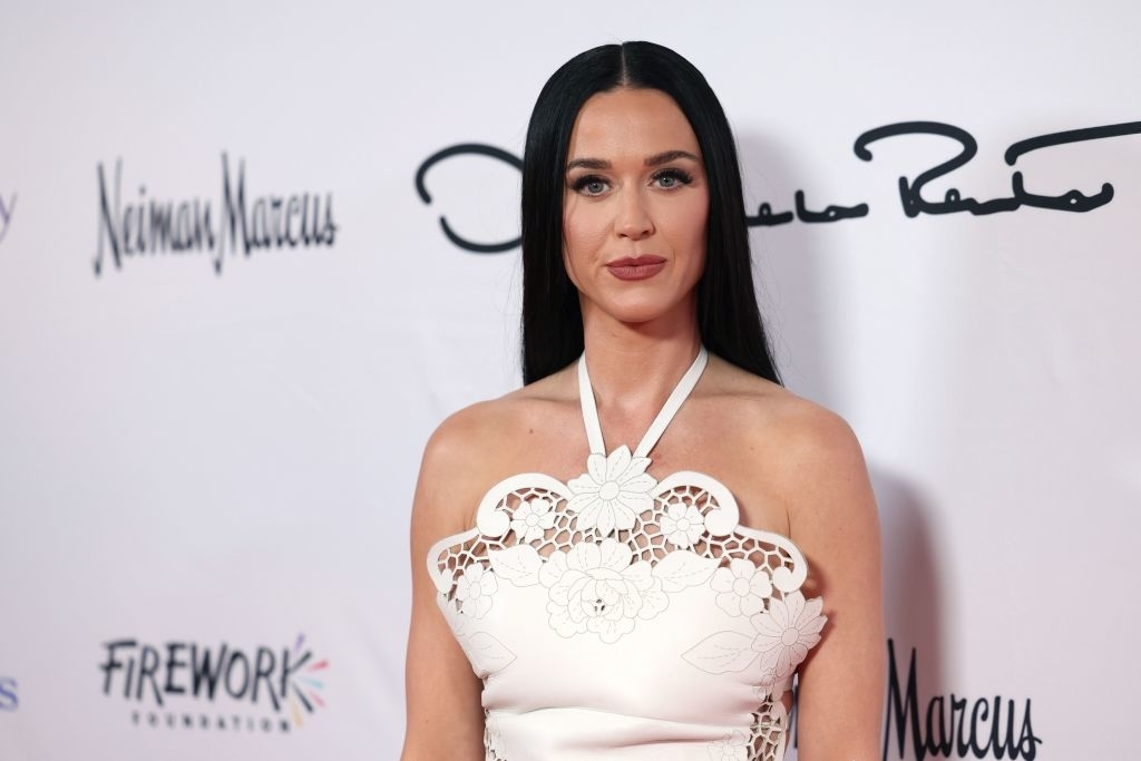 Katy Perry on the red carpet in a halter-style dress with floral lace detailing at an event sponsored by Neiman Marcus and Firework Foundation