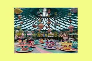 People riding in colorful, spinning teacups under a whimsical, lantern-decorated canopy at Disneyland's Mad Tea Party attraction