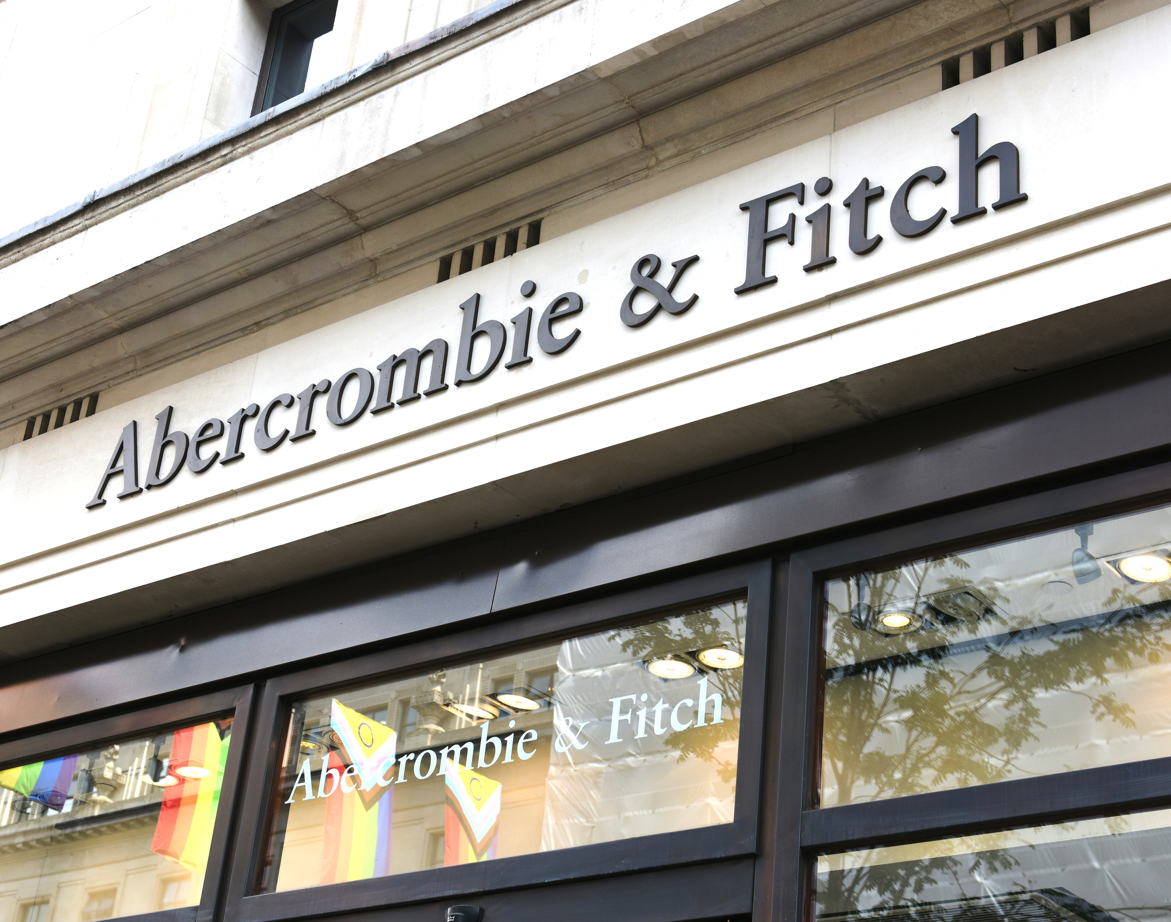 Storefront with &quot;Abercrombie &amp;amp; Fitch&quot; signage above the entrance and rainbow flags displayed in the windows