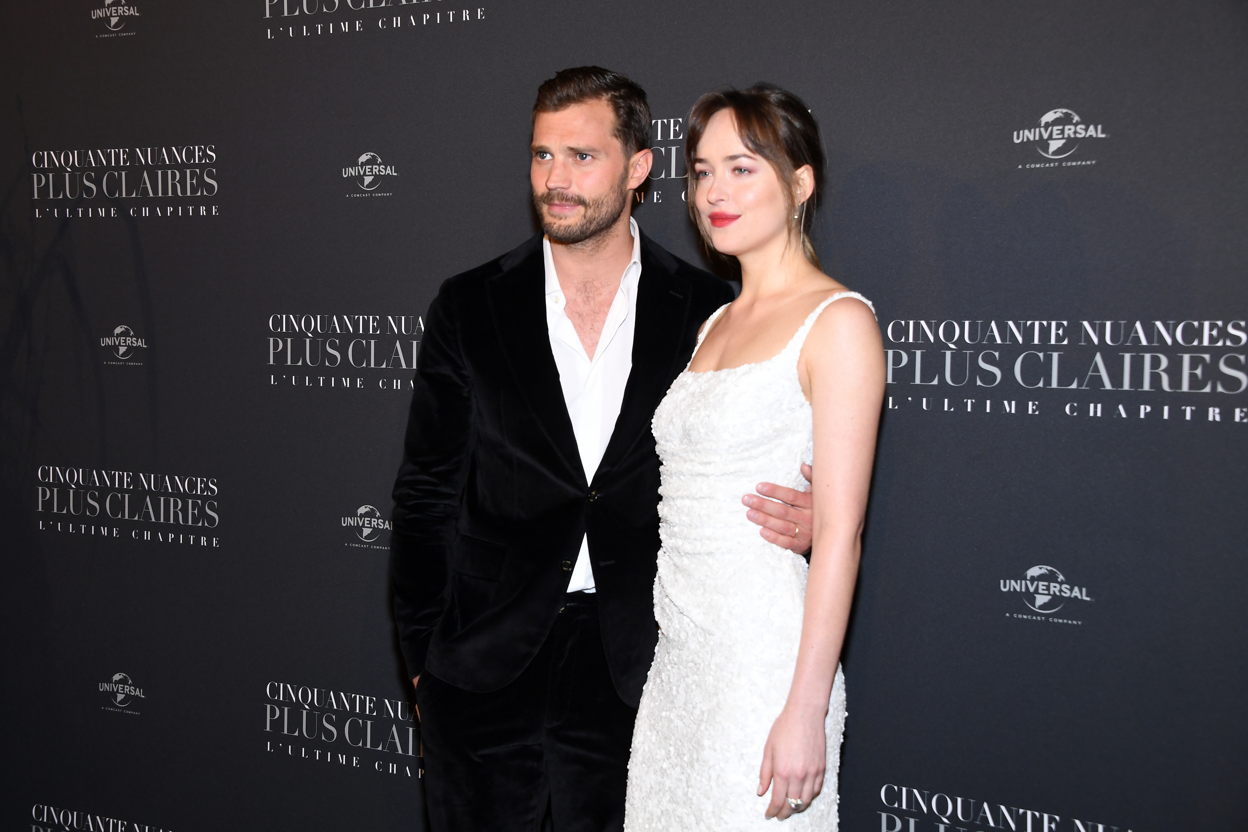 Jamie Dornan and Dakota Johnson pose together at a &quot;Cinquante Nuances Plus Claires&quot; premiere, with Jamie in a black suit and Dakota in a dress