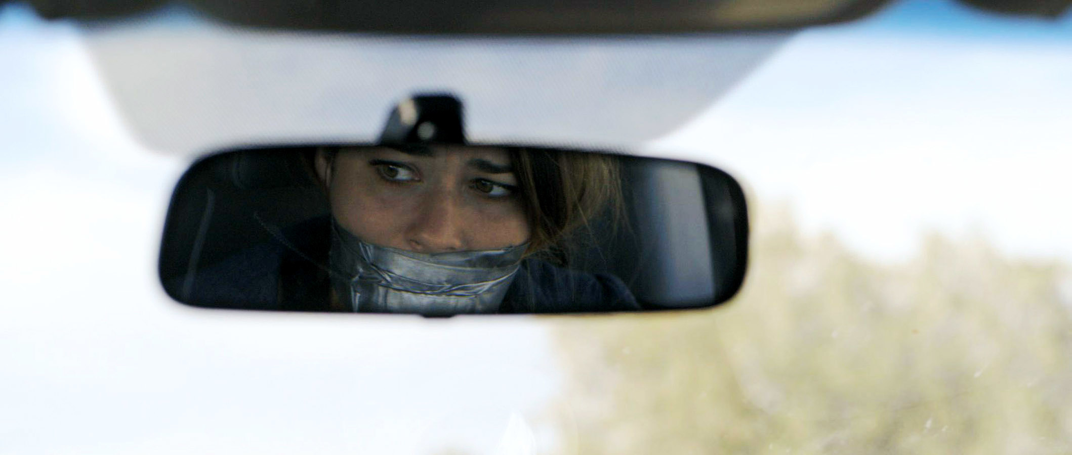 A person is seen in a rear-view mirror with their mouth taped shut, looking worried. The image is from an article categorized as Internet Finds