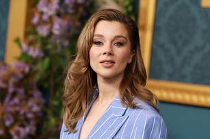 Anya Taylor-Joy wearing a pinstripe blazer at a formal event with a floral background