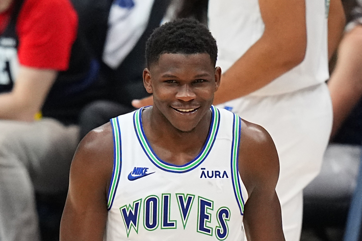 Anthony Edwards smiling while wearing a Wolves basketball jersey during a game