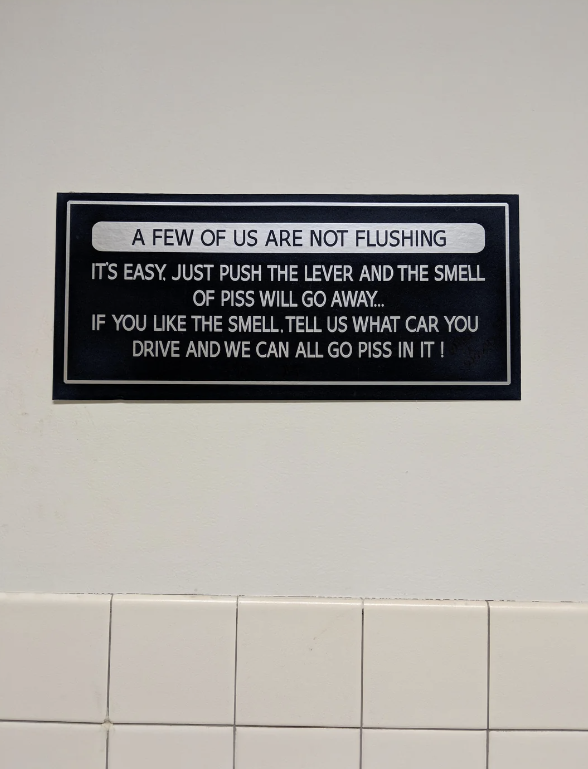 A humorous bathroom sign reads: "A few of us are not flushing. It's easy. Just push the lever and the smell of piss will go away… If you like the smell, tell us what car you drive and we can all go piss in it!"