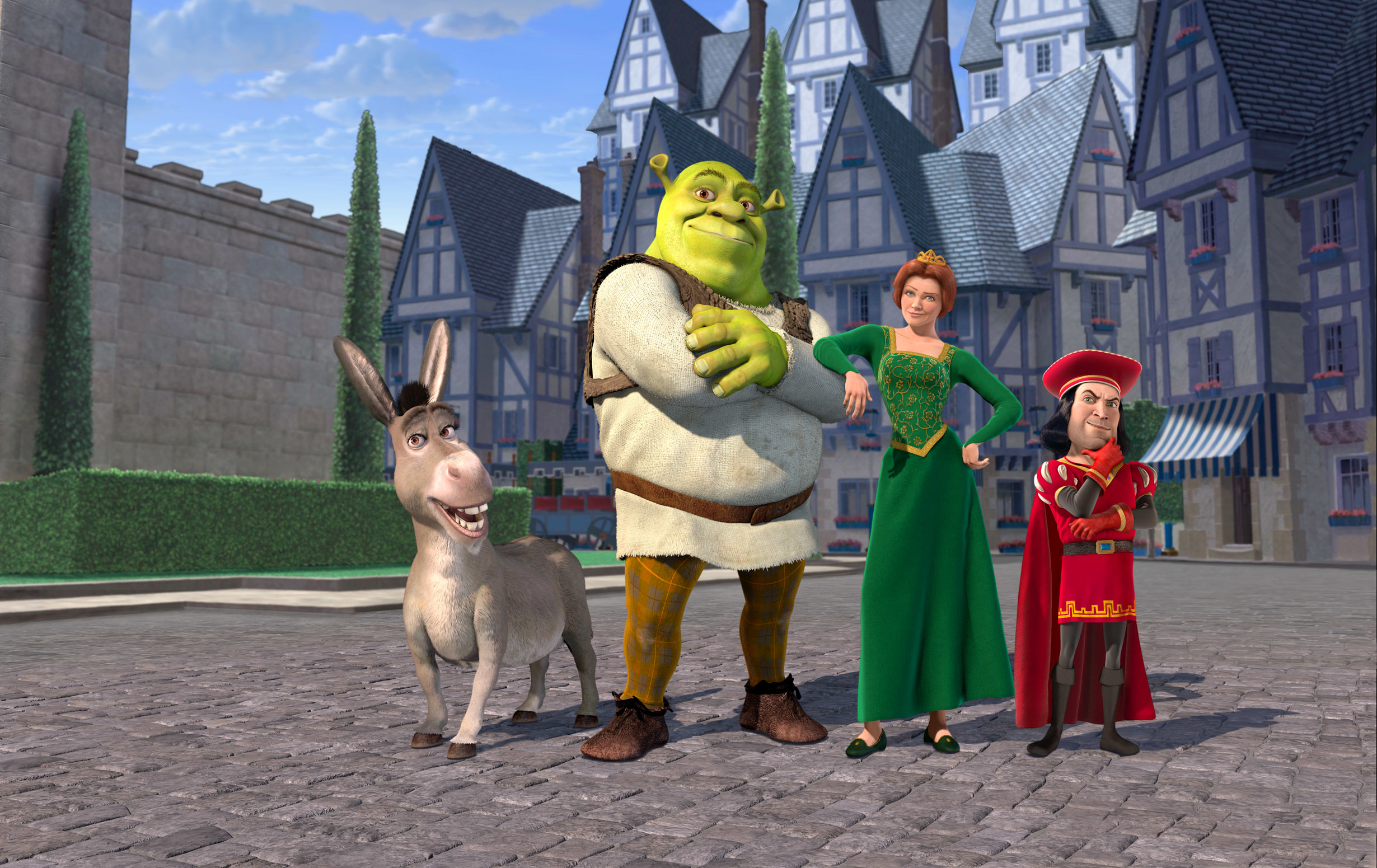 Shrek, Fiona, Donkey, and Lord Farquaad standing together on a cobblestone street in a medieval town in the movie "Shrek."