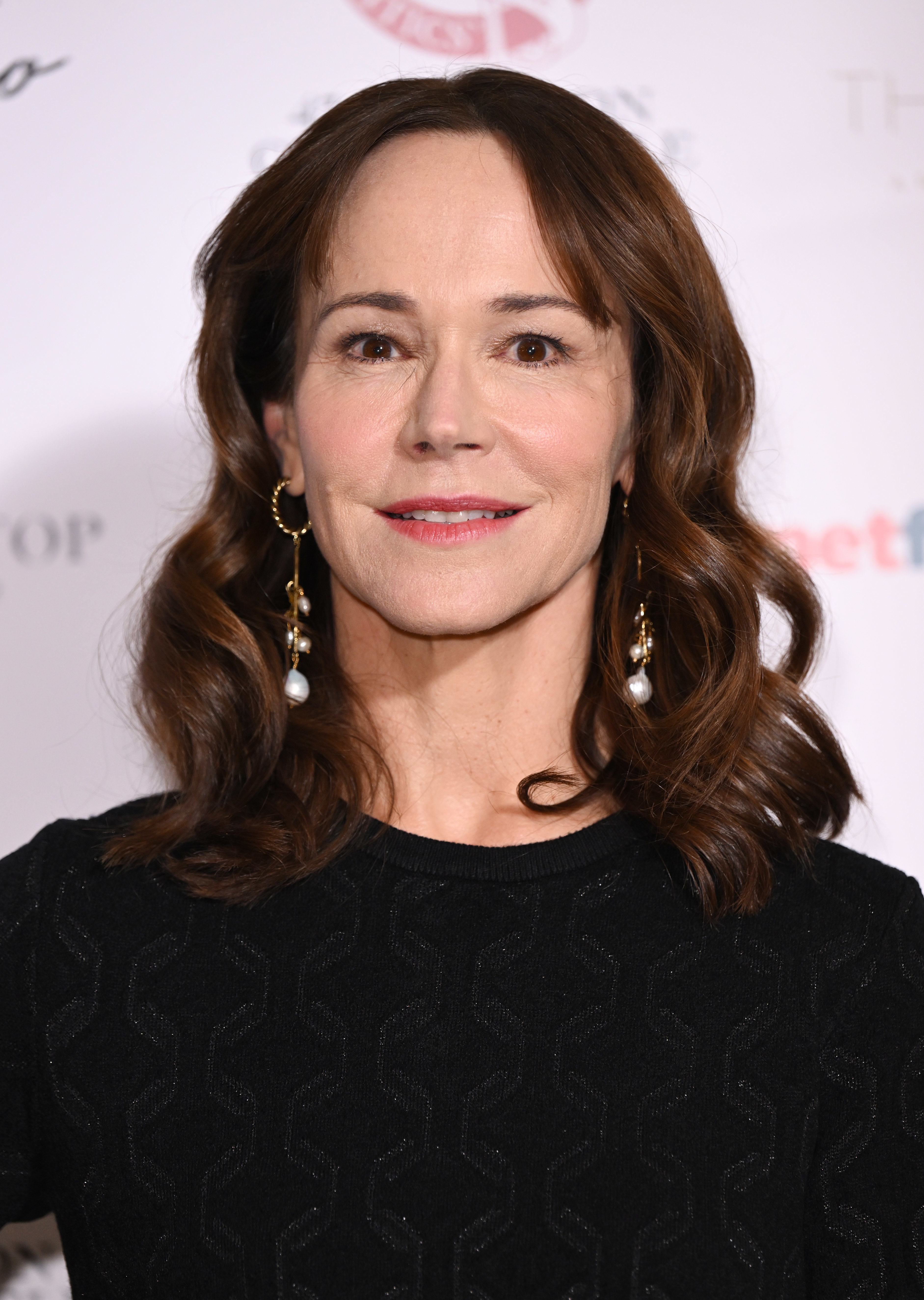 Frances O'Connor at a red carpet event, wearing elegant earrings and a black dress
