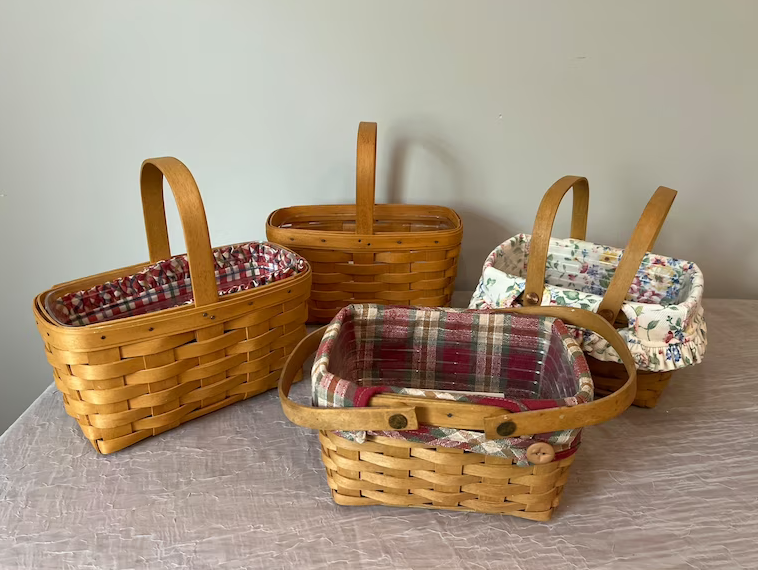 Four woven baskets with handles, each lined with different patterned cloth inserts, displayed on a table
