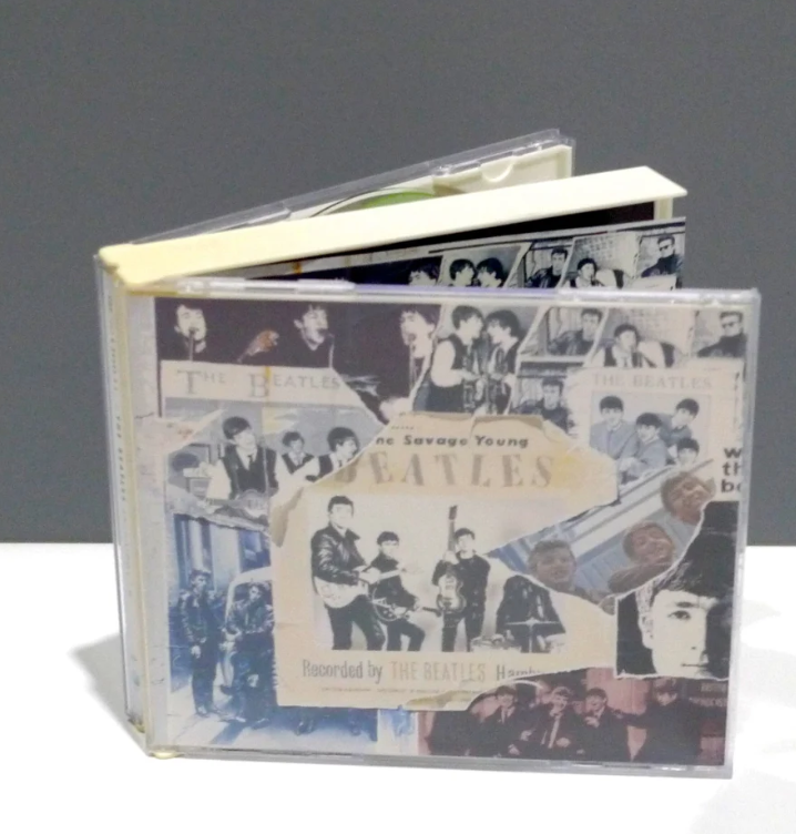 CD case with a collage of photos and text featuring The Beatles, titled "The Savage Young Beatles."