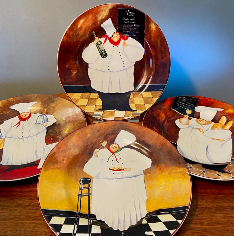 Plates with illustrations of chefs holding various items such as a wine bottle, bread, and a dish, displayed against a dark background