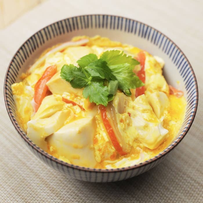 ボウルに卵、豆腐、野菜が入った料理。上にはパクチーが乗っている。