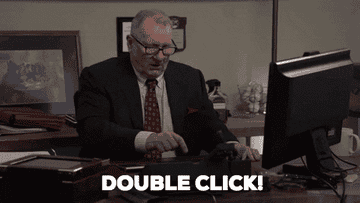 Ed O'Neill sitting at a desk in an office, wears a suit and tie, points at a computer mouse. Text in image: "DOUBLE CLICK!"