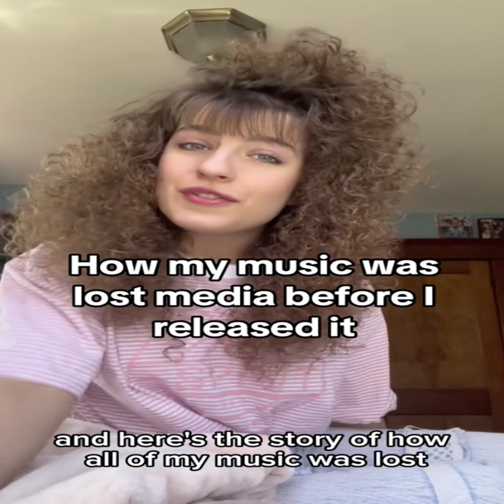 Person with curly hair speaking to camera, text reads: "How my music was lost media before I released it," and "here's the story of how all of my music was lost."