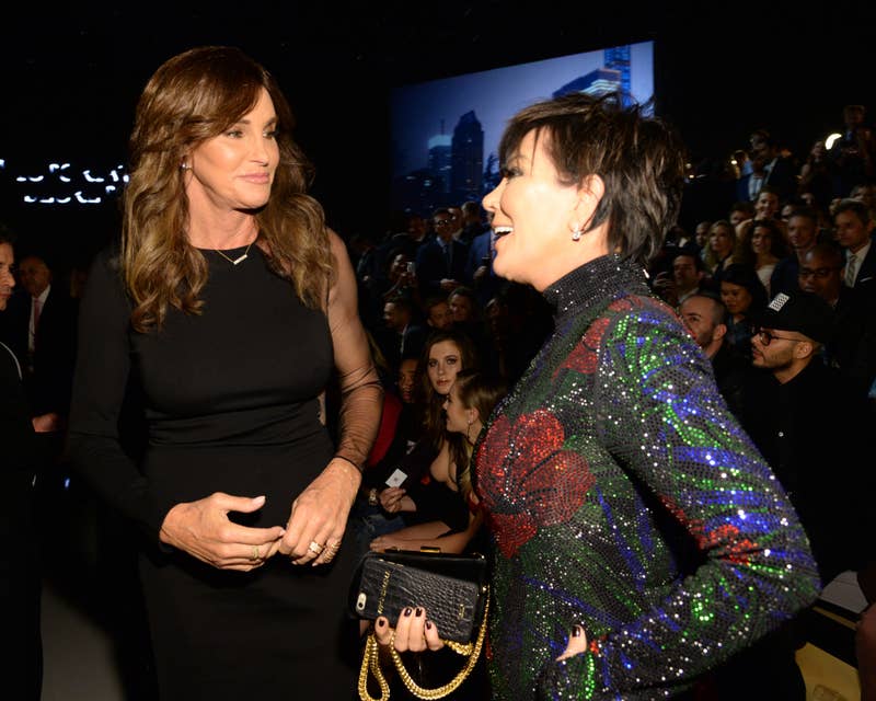 Caitlyn Jenner và Kris Jenner trò chuyện tại một sự kiện công cộng, Caitlyn mặc váy đen còn Kris mặc váy lấp lánh nhiều màu