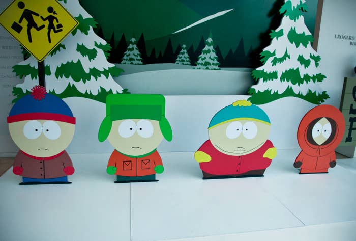 Cartoon characters Stan, Kyle, Cartman, and Kenny from South Park are depicted in a wintery landscape with a school crossing sign