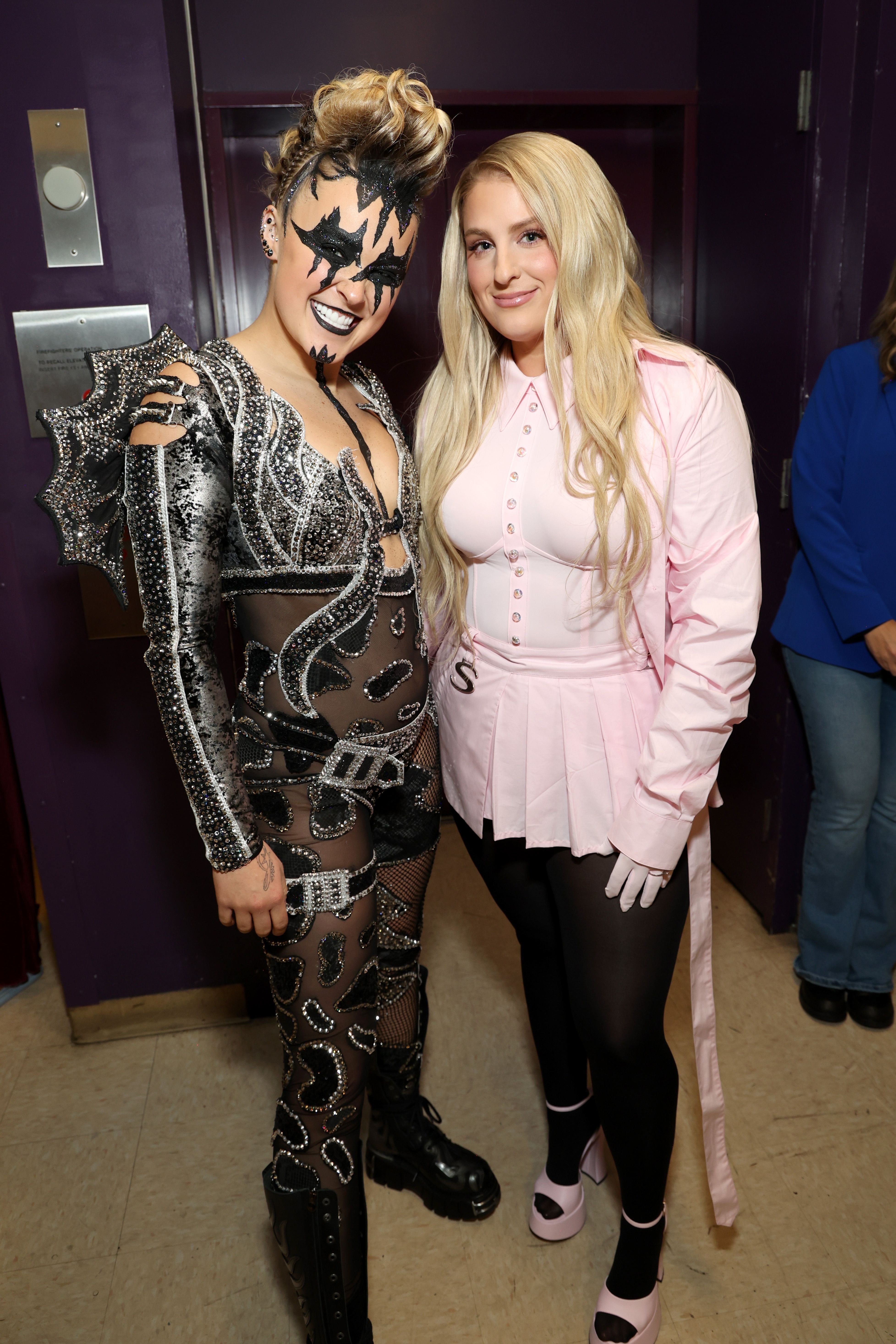P!nk in a rockstar costume and Meghan Trainor in a pink outfit with a skirt, both posing for a photo